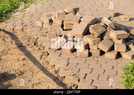 Road repair. Broken asphalt on pedestrian zone in the city street. Road repair work. Construction of pedestrian zone. Damaged asphalt surface Stock Photo