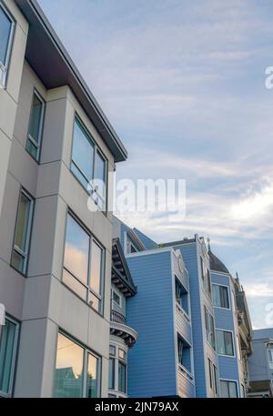 Modern and vitorian multi-storey townhouses in San Francisco, California. There is a modern building on the left with picture windows beside the townh Stock Photo