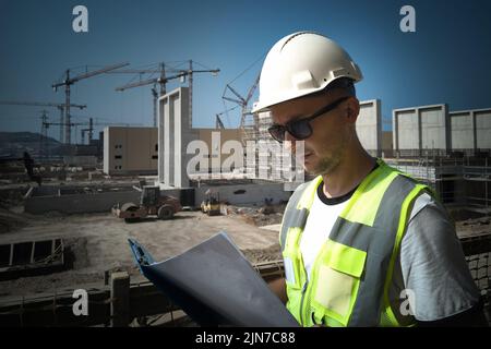 Construction site engineer opposite industrial background Stock Photo