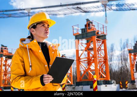 Women engineer at work in constructions with digital tablet, supervising
