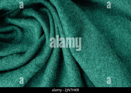 Green soft woolen cozy scarf texture close-up. Stock Photo
