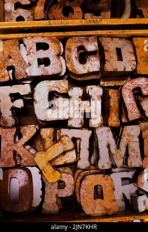 Old metal letters being sold at a flea market.  Good for concept background.  Rough and rustic, with rust and weld marks. Stock Photo