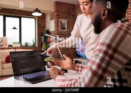 Programmers couple coding security firewall on laptop, using html and temrinal window to develop new user interface. Learnign to program software using cloud computing app server. Stock Photo