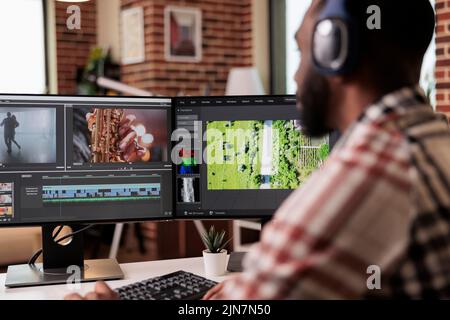 Graphic designer editing footage on software, working to edit video montage with color grading and audio effects. Sound and film production content, making creative movie on computer. Stock Photo