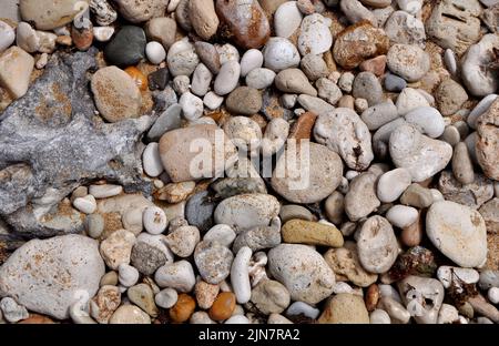 Multicolored pebbles and beach sand Stock Photo
