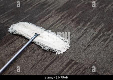 Use Clean White Mop on brown Carpet. Stock Photo