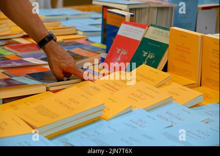 A man pointing to a book he chooses on the booth stall at the book fair Stock Photo