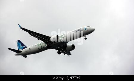 AZORES AIRLINES AIRBUS A321NEO midair, approaching landing, view from below on background of cloudy skies, Ponta Delgada, Sao Miguel, Azores, Portugal Stock Photo