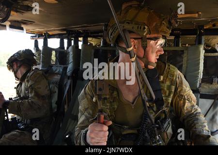 Australian soldiers from 5th Battalion Royal Australian Regiment await the signal to begin dismounting from the UH-60 Blackhawk helicopter for their joint training rehearsal as part of Super Garuda Shield 2022 in Baturaja, Indonesia, Aug. 8, 2022. Super Garuda Shield, a part of Operation Pathways and a longstanding annual, bilateral military exercise conducted between the U.S. military, Indonesia National Armed Forces, has now expanded to a multinational exercise encompassing 14 Nations. This exercise reinforces the U.S. commitments to our allies, and other regional partners reinforcing joint Stock Photo