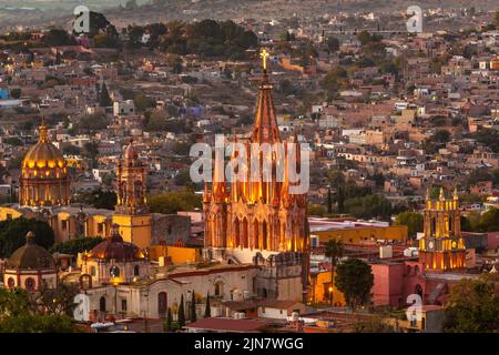 Colorful sunset over the Parroquia de San Miguel Arcangel and San Francisco church steeples in the historic district viewed from the hillside neighborhood of Los Balcones in San Miguel de Allende, Mexico.