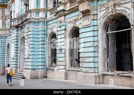 Kharkiv, Ukraine. 01st Aug, 2022. A young woman walks past a damaged building with broken windows and a damaged facade of the building due to Russian shelling in Kharkiv. (Photo by Mykhaylo Palinchak/SOPA Images/Sipa USA) Credit: Sipa USA/Alamy Live News Stock Photo