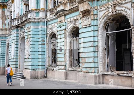 Kharkiv, Ukraine. 1st Aug, 2022. A young woman walks past a damaged building with broken windows and a damaged facade of the building due to Russian shelling in Kharkiv. (Credit Image: © Mykhaylo Palinchak/SOPA Images via ZUMA Press Wire) Stock Photo