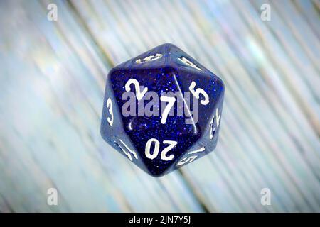 Lucky number seven on a sparkly blue twenty-sided adventure game die. Stock Photo