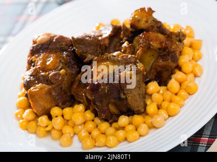 Braised oxtails with chickpeas on a white plate Stock Photo