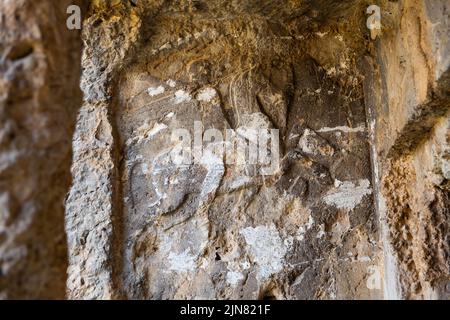 Carved stone reliefs in cliff near ancient rock tombs in Tlos, Turkey Stock Photo