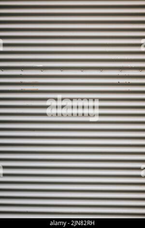 A vertical shot of a closed metal roll-up door of a store Stock Photo