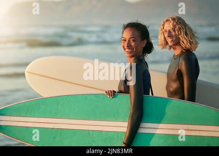 Were always having fun together. a cheerful young couple going surfing at the beach. Stock Photo