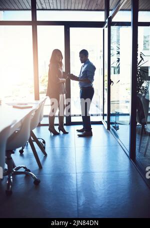 Business people or professional managers talking about project management, discussing schedule and planning. Young businessman and businesswoman Stock Photo