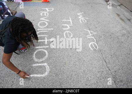 Ferguson, United States. 09th Aug, 2022. Christine Hendricks writes a message with chalk as family celebrate the life of Michael Brown at the place where he was shot dead eight years ago, in Ferguson, Missouri on Tuesday August 9, 2022. On August 9, 2014, Michael Brown Jr. was fatally shot by Ferguson Police Officer Darren Wilson after a altercation ensued. Johnson was with Brown at the time of the shooting.This event ignited unrest in Ferguson. Photo by Bill Greenblatt/UPI Credit: UPI/Alamy Live News Stock Photo