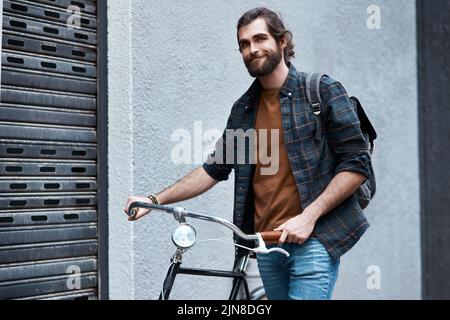 Im always down for a trip. a handsome young man travelling with his bicycle outdoors. Stock Photo