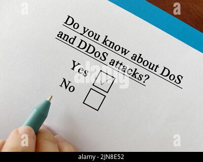 One person is answering question about cyber attack. He knows about Denial of Service (DoS) and Distributed Denial of Service (DDoS) Stock Photo