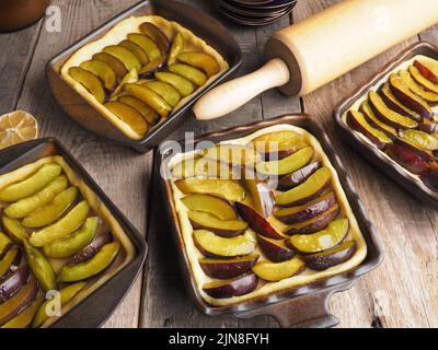 Plum cake prepared for baking on a rustic wooden kitchen table, organic food, seasonal bakery Stock Photo