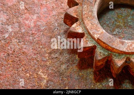 closeup rusty gear fragment on the grunge metallic surface Stock Photo