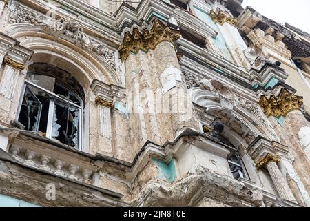 KHARKIV, UKRAINE - Aug. 01, 2022: Damaged architectural monument of the city of  Kharkiv. Destroyed building in historical downtown as a consequences of Russian shelling in Kharkiv. Stock Photo