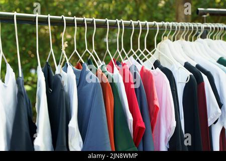 Colored clothes, T-shirts, on hangers in the market. High quality photo Stock Photo
