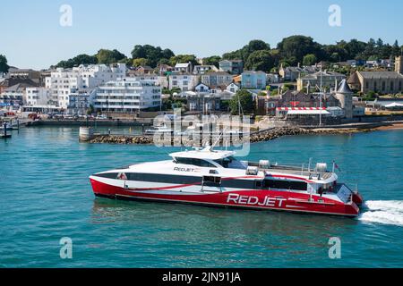 The Red Jet, a high speed catamaran operated by Red Funnel, makes its way in to West Cowes on the Isle of Wight in the summer holidays. Stock Photo
