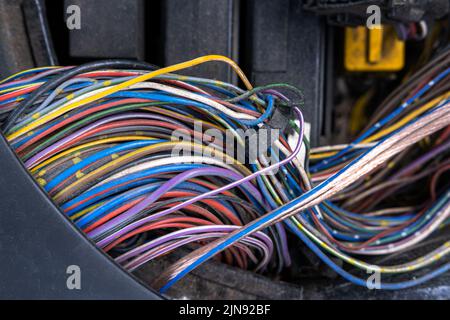 A bundle of electrical wires or cables is strongly mixed up with each other. Remnants of wires of different colors. There are compressed tips on the w Stock Photo