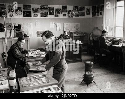 Interior of the Photographic Office of the RAF Public Relations (Overseas) Unit at Allied Forces Headquarters at Caserta, Italy, where personnel are seen sorting and captioning prints of RAF official photographs for distribution to the news media. Stock Photo