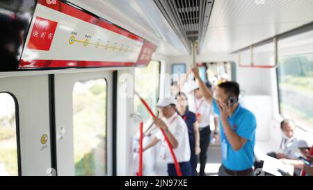 (220810) -- XINGGUO, Aug. 10, 2022 (Xinhua) -- Passengers are seen on a train on the maglev line 'Rainbow' in east China's Jiangxi Province, Aug. 9, 2022. China on Tuesday completed the construction of the country's first independently-developed trial line using rare earth permanent magnetic levitation (PML) technology.   Dubbed 'Rainbow,' the maglev line that is about 800 meters long was built in Xingguo County, east China's Jiangxi Province.    With a designed maximum speed of 80 kilometers per hour, the rail system now can serve a two-carriage maglev train with a carrying capacity of 88 peo Stock Photo