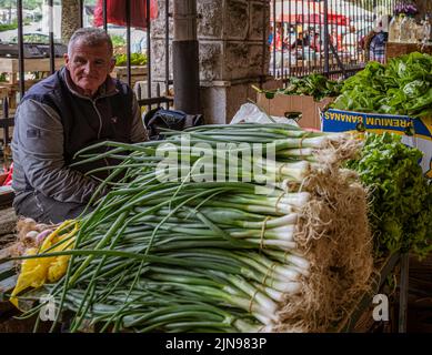 Montenegro - May 7, 2022 - Man sells vegetables at a stall in the market. Stock Photo