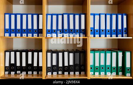 A bookshelf with many different folders on it. There are many different folders on the bookshelf at school. Stock Photo