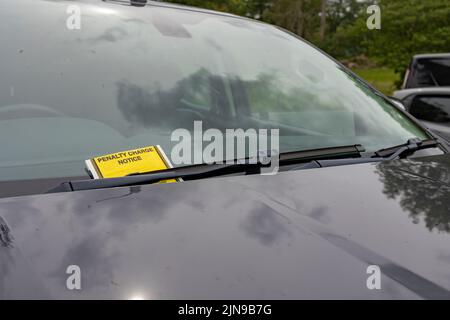 yellow Parking ticket stuck on car windscreen a penalty or fine Stock Photo