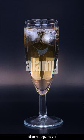 Champagne glass with ice cubes on a black background, close-up Stock Photo