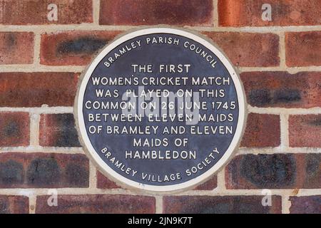 Plaque commemorating the first women's cricket match in 1745 on Bramley Village cricket club building, Gosden Common, Surrey, England, UK Stock Photo