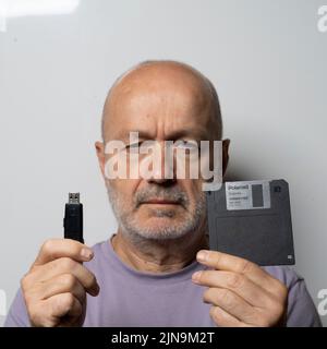 the comparison between an old floppy disk and a USB key for data storage Stock Photo