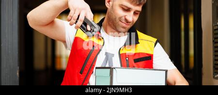 The young courier scans the boxes in order to deliver them Stock Photo