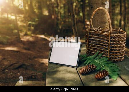 Tablet mockup on the background of nature in the forest. Workplace in nature, ipad mockup with blank white screen Stock Photo
