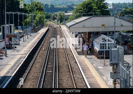 People waiting on the platform at a railway station on the South Western line at Petersfield, Hampshire UK. Stock Photo