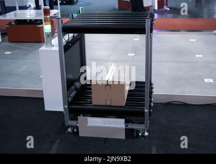 Industry shuttle robot carry carton in modern warehouse factory. Automated guided vehicle AGV. Stock Photo