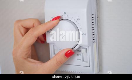 Manually adjust temperature in central heating control panel Stock Photo