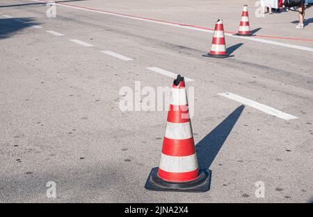 Traffic cones with white and red stripes on the road of the airport. Safety cone Stock Photo