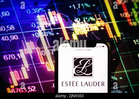 In this photo illustration the stock market graphic of the Estee Lauder  Companies Inc seen displayed on a smartphone with a logo of the Estee Lauder  Companies Inc in the background Stock