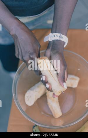 woman chef preparing african caribbean food with plantain plane tree fruit Stock Photo