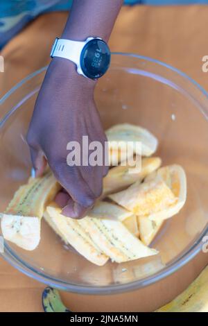 woman chef preparing african caribbean food with plantain plane tree fruit Stock Photo