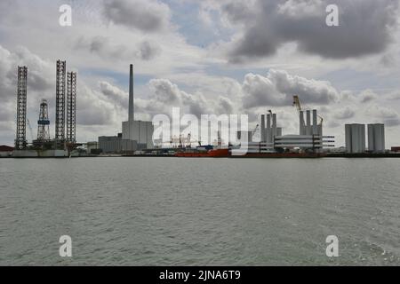 View of offshore oil rig and wind turbine components on the harbour dock, Esbjerg, Jutland, Denmark Stock Photo