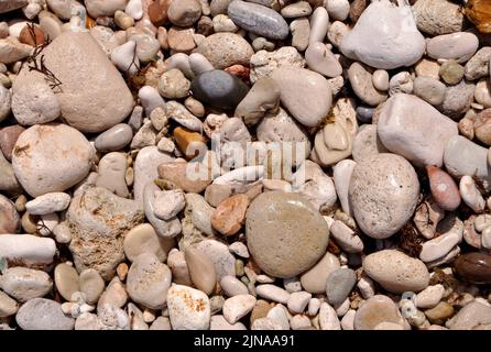 Multicolored pebbles and beach sand Stock Photo